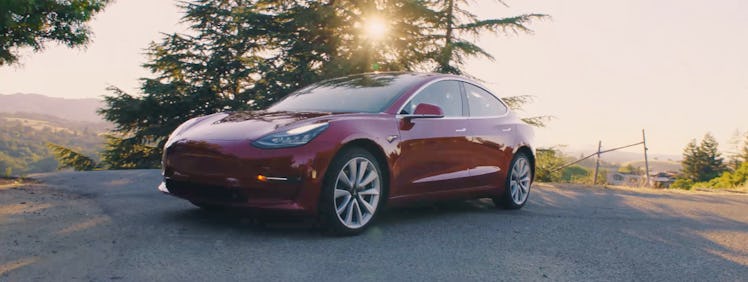 The red Tesla Model 3 on the road