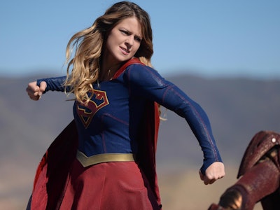 Supergirl swinging her arm to punch someone