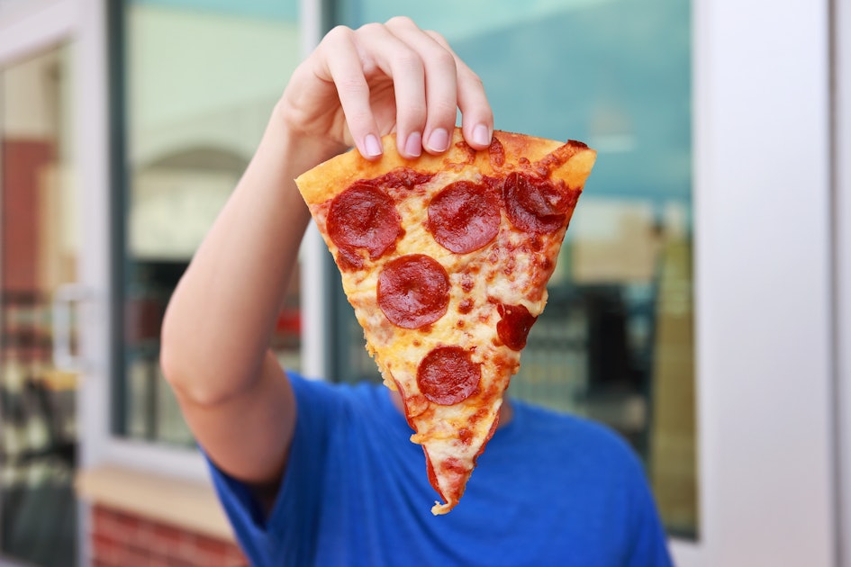 Девочка кушает пиццу пепперони