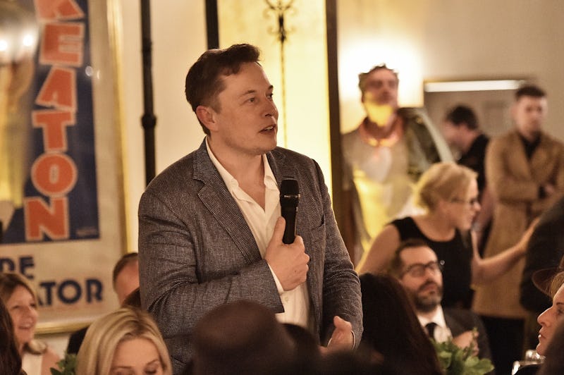Elon Musk holding a microphone during his speech