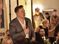 Elon Musk holding a microphone during his speech