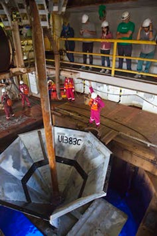 The re-entry cone is welded together around the drill pipe, then lowered down the pipe to guide rein...