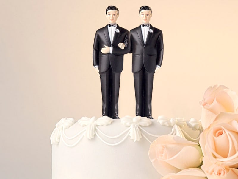 Same-sex wedding cake with two men in formal suits on top