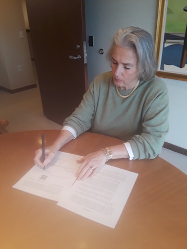 Purcell signing the blockchain-enabled deed.