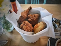 A white bowl with crispy fried chicken