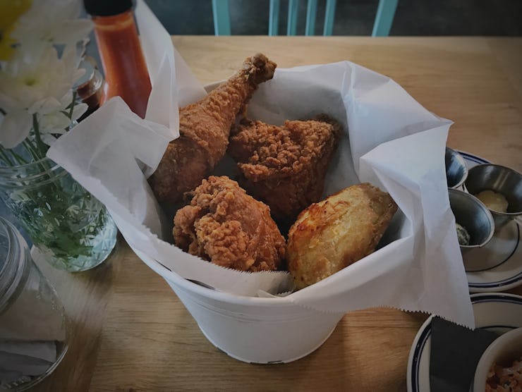 A white bowl with crispy fried chicken