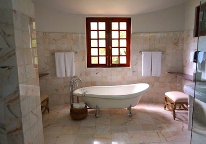 A spacious bathroom with a white tub in the middle
