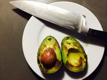 A ripe avocado sits prominently, flanked by a flurry of diced