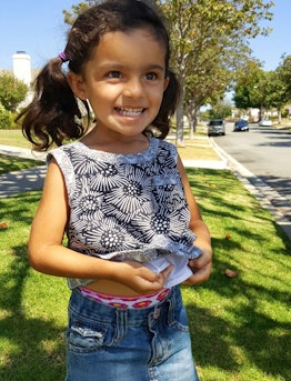 A little girl with a grey shirt and blue denim jeans whose mom has PCOS