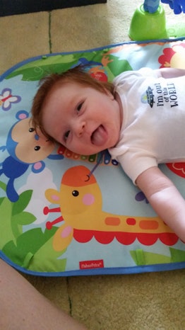 A newborn baby smiling an lying on its back whose mom has PCOS