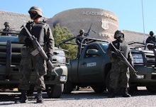 Armed Mexican police standing in front the police academy due to violence between drug cartels and l...