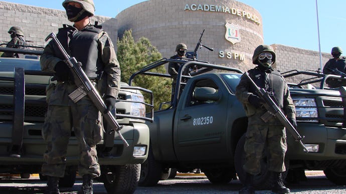 Armed Mexican police standing in front the police academy due to violence between drug cartels and l...