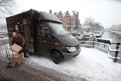 A UPS truck and delivery man holding a package