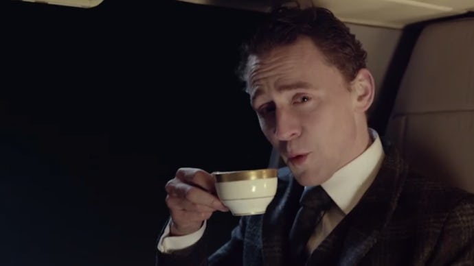 Tom Hiddleston in a suit holding a cup of tea in a super bowl ad