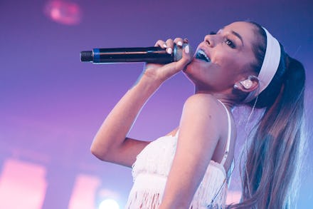 Ariana Grande singing into a microphone on stage