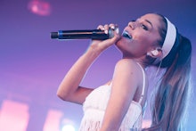 Ariana Grande singing into a microphone on stage