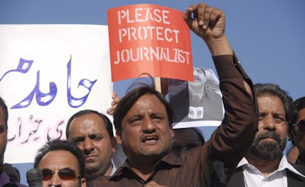 A group of protesters holding a 'Please Protect Journalists' poster in a country with no 'Free' Pres...