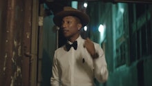 Pharrell Williams in a white shirt, black bow tie and grey hat
