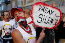 A man holding a protest banner with "Break the silence" text