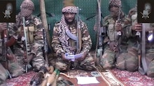 Boko Haram soldiers with weapons sitting on the floor