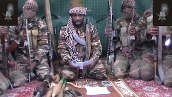 Boko Haram soldiers with weapons sitting on the floor