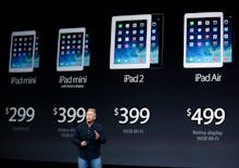 A man talking about Apple's four iPad products, that are visible on a wall behind him, with their pr...