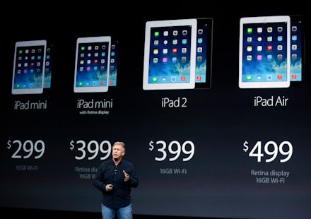 A man talking about Apple's four iPad products, that are visible on a wall behind him, with their pr...