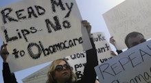 Protesters, with a woman holding a sign that says read my lips no to obamacare