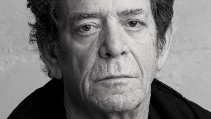 A closeup of Lou Reed in black and white wearing a plain black sweater and black jacket