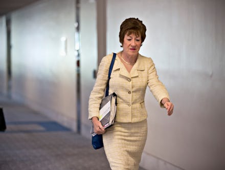 Sen. Susan Collins (R-Maine) walking down the hall while holding a folder full of papers