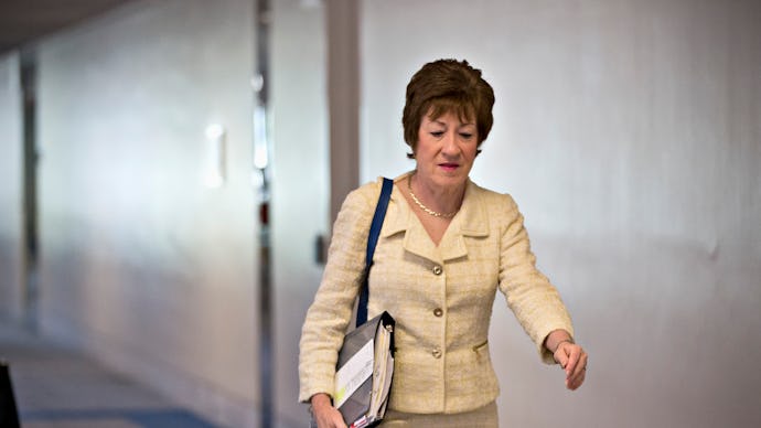 Sen. Susan Collins (R-Maine) walking down the hall while holding a folder full of papers