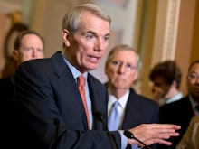 Rob Portman at the forefront talking to the press and Mitch McConnell in the background 