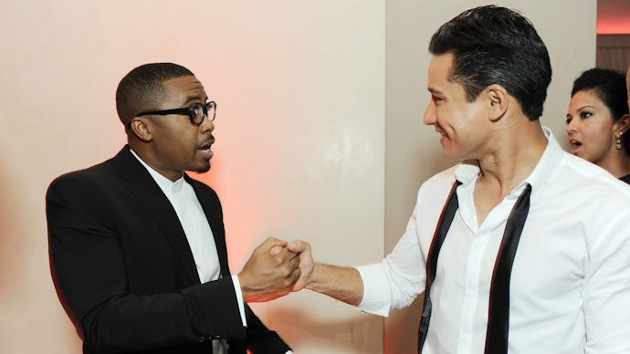 Nas in a suite shaking hands with Mario Lopez in a white shirt with his bowtie untied hanging around...