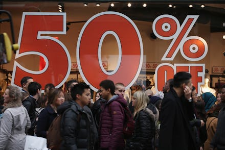 A large crowd in front of a store with the best boxing day deals and a large 50% sign