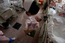 A nurse holding a newborn baby in the hospital