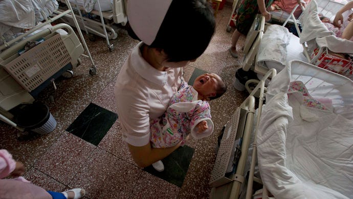 A nurse holding a newborn baby in the hospital