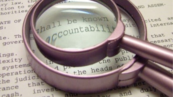 A smaller magnifier on top of a bigger one pointing out the word 'accountability' in a paragraph