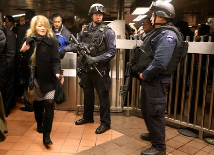 Police officers serving as securty at an airport in america as a woman walks past