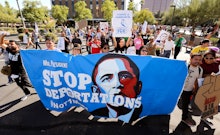 A crowd in the San Francisco ICE protests holding a poster with a picture of Obama and the text 'Sto...