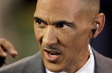 A closeup of Tony Dungy with an earphone looking angry