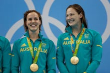 Cate and Bronte Campbell, Sisters and Olympic Swimmers posing together and smiling with their medals