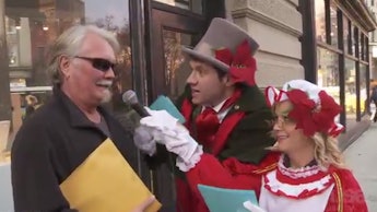 Amy Poehler and Billy Eichner in their viral video of the day interviewing a man in a holiday ambush