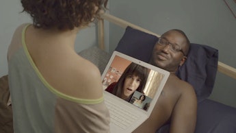 A man laying down and a girl talking to her friend on a laptop, a scene from "Broad City", where fem...