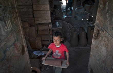 A little boy carrying a heavy object as a modern slave