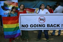 A group of people protesting India's Ban on gay sex with a large poster 'NO GOING BACK'