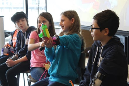 Kids with 3-d printed prosthetics sitting next to each other