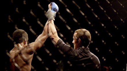 A judge announcing a winner of a martial art match by raising his hand