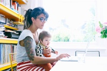 A woman holding a baby girl on her lap at her workplace