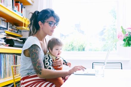 A woman holding a baby girl on her lap at her workplace