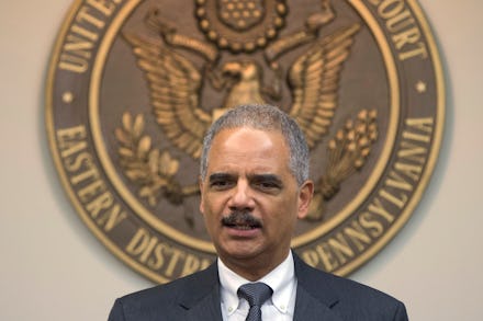 Eric Holder in a suit and tie with the Eastern District Pennsylvania emblem behind him